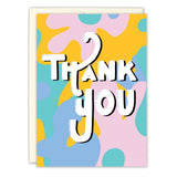 The Retro Thank You Card by Natalie Henry Charles features colorful abstract shapes and bold “Thank You” text. A partially visible envelope sits behind the illustrated card.