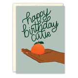The Lifting Me Up Thank You card by Tiffany Grimes features a brown-skinned hand with pink-painted nails holding an orange on a light green background, printed on recycled paper.