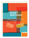 The Stiff Drink Birthday Card by Andrea Williams features a vibrant geometric design with two illustrated whiskey glasses toasting over ice and the text HERES A STIFF DRINK. HAPPY BIRTHDAY. Printed on premium recycled paper with envelope.
