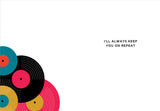 Four colorful vinyl records are stacked in the lower left corner on a white background of the Favorite Song Love Card by Andrea Williams. To the right, black text reads, ILL ALWAYS KEEP YOU ON REPEAT.