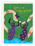 Two women in colorful dresses with swirling butterfly banners appear on a green background. “You are magnificent” is written above. This vibrant Cherrymae Golston “You Are Magnificent Birthday Card” features foil accents and recycled paper.