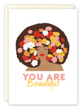 Illustration of a woman with closed eyes and colorful flower-filled curly hair, with “You Are Beautiful” in pink and yellow below. You Are Beautiful Encouragement Card by Lauren-Ashley Barnes.