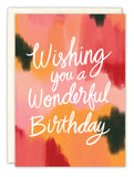 The Wonderful Watercolor Birthday Card by Lauren-Ashley Barnes features a pink, orange, and black watercolor background with white handwritten Wishing you a Wonderful Birthday text and comes with an envelope.