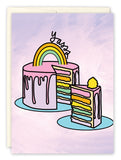 The Yasss Birthday Card by Natalie Henry Charles features a pastel pink cake with rainbow layers and icing, topped with a rainbow and yasss. A slice sits on a blue plate—perfect for celebrating a Happy Birthday in colorful style.