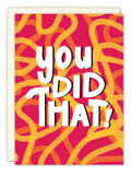 The You Did That Congrats Card by Natalie Henry Charles features bold white text on a red background with yellow and orange swirls, adding vibrant flair. An off-white recycled paper envelope is partially visible behind the card.