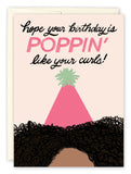 The Poppin Birthday Card by Tiffany Grimes is a colorful greeting card on recycled paper with text: Hope your birthday is poppin like your curls! Features curly hair and a pink party hat topped with a green pom-pom.