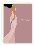The At Last Wedding Card by Tiffany McGraw features a woman in a strapless blush pink gown with green foliage on a mauve background, with At last in elegant script—ideal for congratulations or as an art print.