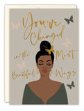The Youve Changed Birthday Card by Tiffany McGraw features a dark-skinned woman with a bun, closed eyes, earrings, and off-shoulder top. Gold script reads “You’ve changed in the most beautiful ways,” with butterflies on recycled paper.